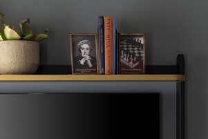 Ein Regal mit Büchern und gerahmten Bildern.