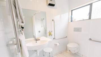 Een moderne badkamer met een wastafel, spiegel, toilet en douche.