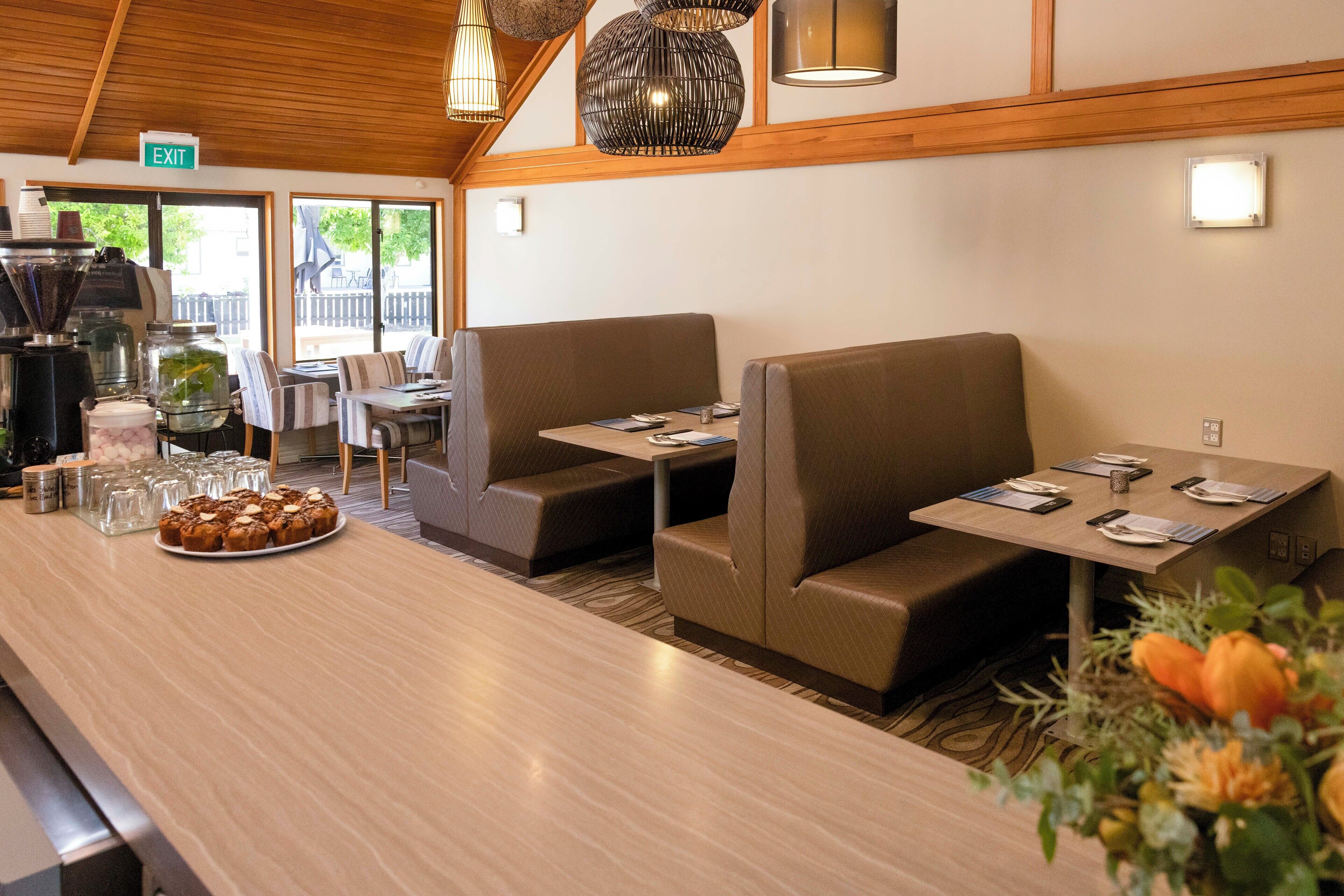 A restaurant with booths and a counter, equipped with a coffee machine and a variety of condiments.