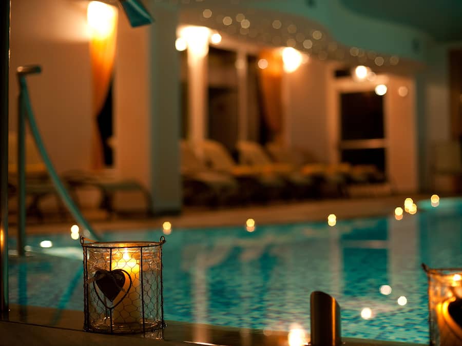 Een binnenzwembad, ligstoelen bij het zwembad