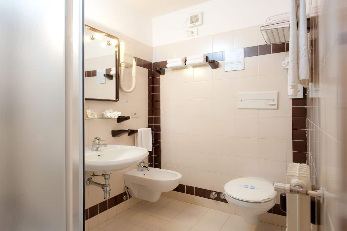 A bathroom with a sink, bidet, and toilet.