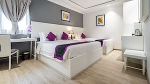 Une chambre d’hôtel moderne, dotée d’un grand lit, d’un bureau et d’une chaise.