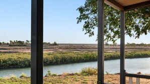 Vista del río desde un espacio cubierto, con vegetación circundante.