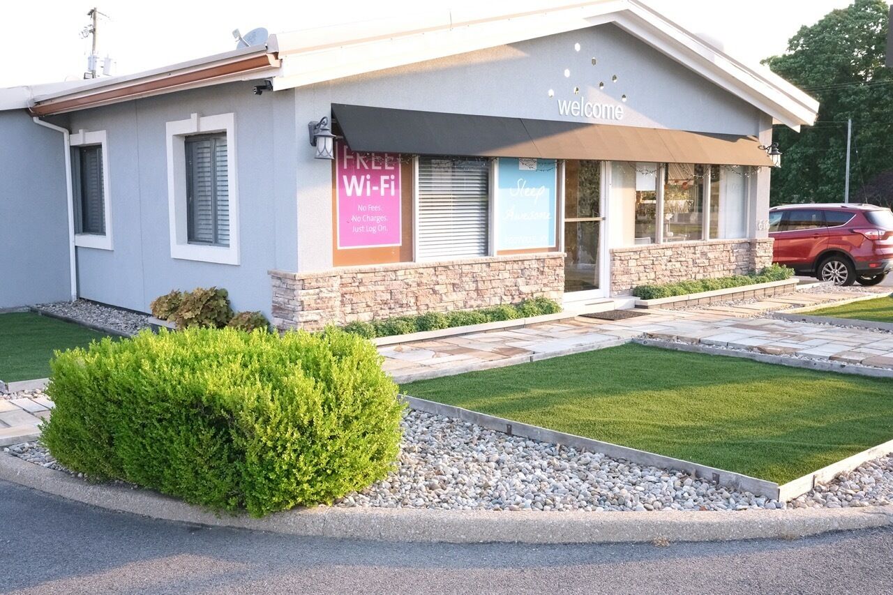A building with a 'Welcome' sign, a 'Free Wi-Fi' sign, and a 'Sleep Here' sign.