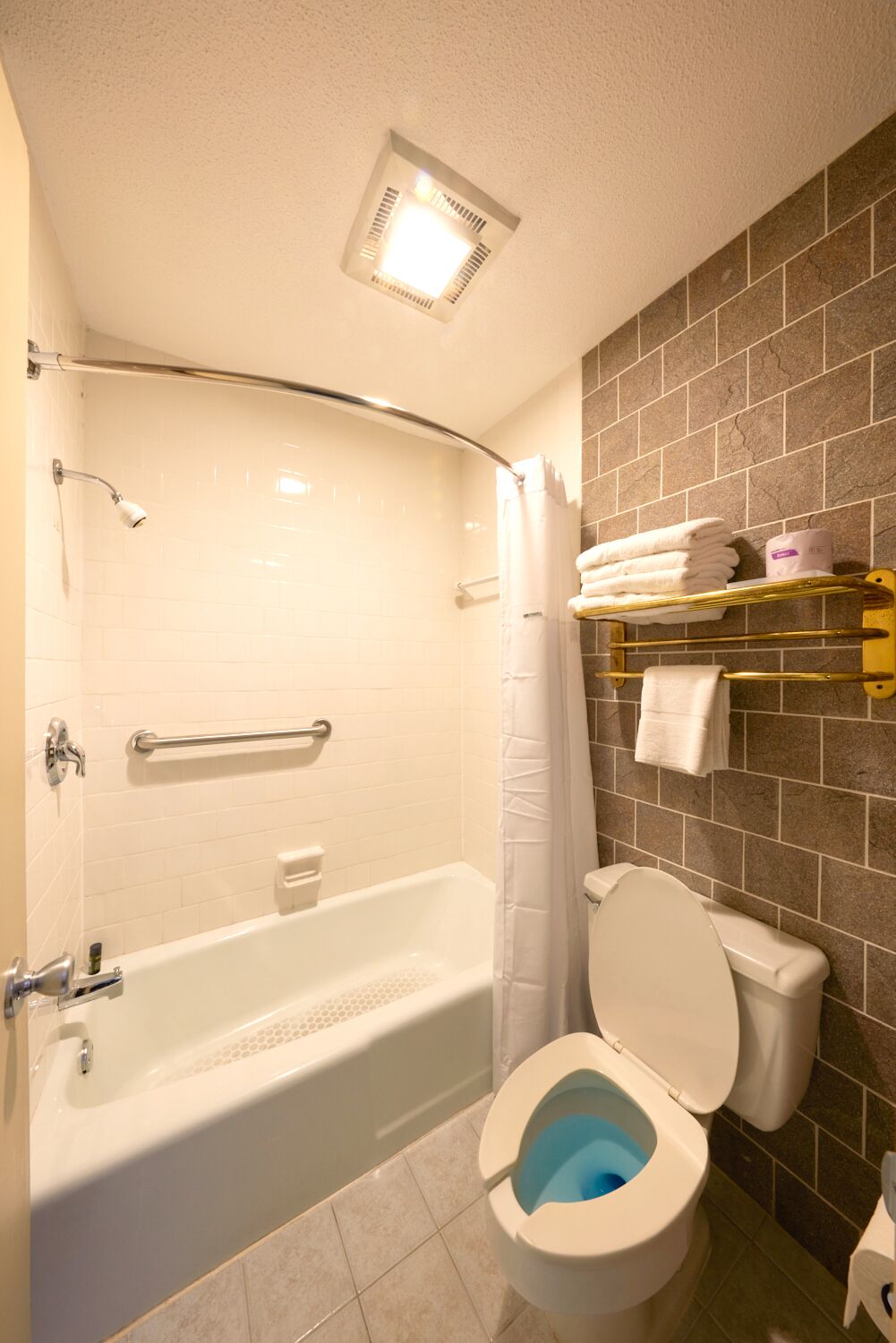 A bathroom with a bathtub, toilet, and a shower area.