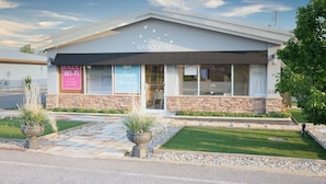 A modern building with a 'welcome' sign, a 'Free Wi-Fi' sign, and a 'Sleep Awesom' sign. - Regency Inn (Eddyville)