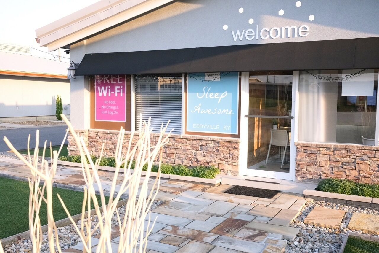 A building with a 'Welcome' sign, a 'Free Wi-Fi' sign, and a 'Sleep Awesome' sign.