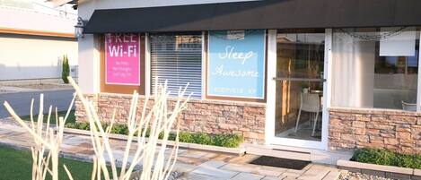 A building with a 'Welcome' sign, a 'Free Wi-Fi' sign, and a 'Sleep Awesome' sign.