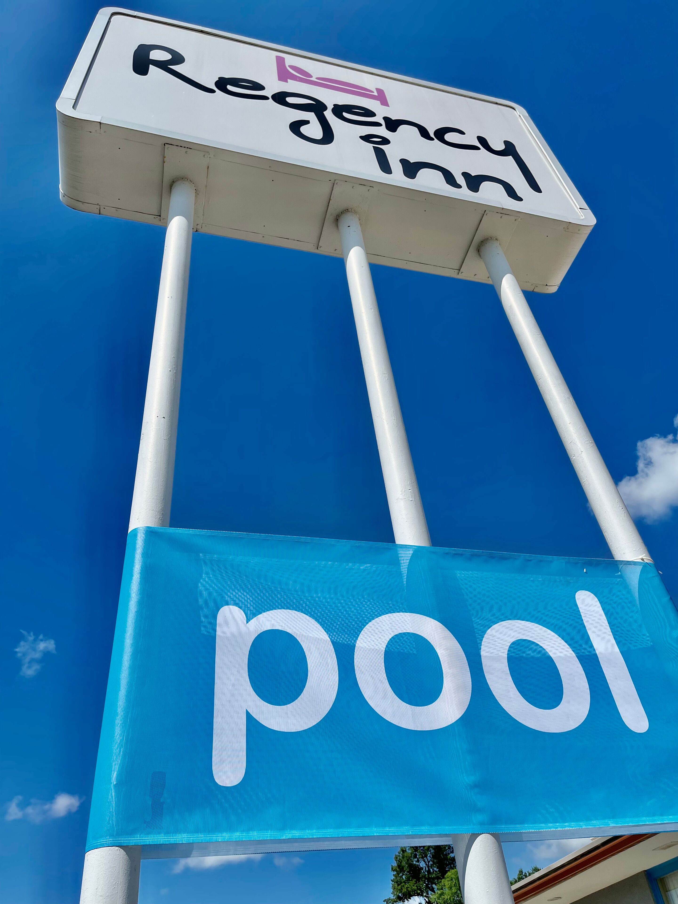 A sign for a Regal Inn with a pool.