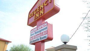 Schild für das Regency Inn mit einem 'ERÖFFNET' Banner, das neue Leitung, kostenlose HD-Kanäle und WLAN anzeigt.