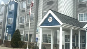 A multi-story residential building with a central entrance featuring a covered porch. - Microtel Inn & Suites by Wyndham Mansfield (Mansfield)