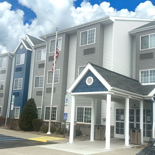 A multi-story residential building with a central entrance featuring a covered porch. - Microtel Inn & Suites by Wyndham Mansfield (Mansfield)