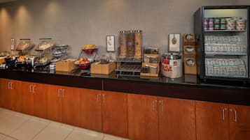 Un bufé de desayuno con diversas opciones de comida y una sección refrigerada con bebidas.