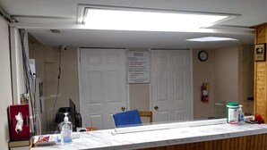 A reception desk with a sign indicating check-in times and a note about no personal cheques. - Relax Inn Collingwood (Collingwood)