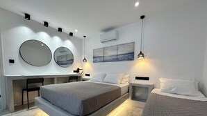 Un dormitorio moderno con una cama grande, una cama más pequeña, un escritorio y una silla.