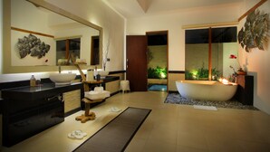 A modern bathroom with a freestanding bathtub, a large mirror, and a sink with a wooden stool. - Ashoka Tree Resort at Tanggayuda, Ubud (Ubud)