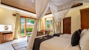 A bedroom with a canopy bed, a television, and a view of the outdoors. - Ashoka Tree Resort at Tanggayuda, Ubud (Ubud)