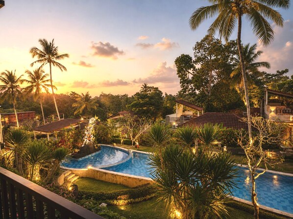 A resort with a swimming pool, palm trees, and houses. - Ashoka Tree Resort at Tanggayuda, Ubud (Ubud)