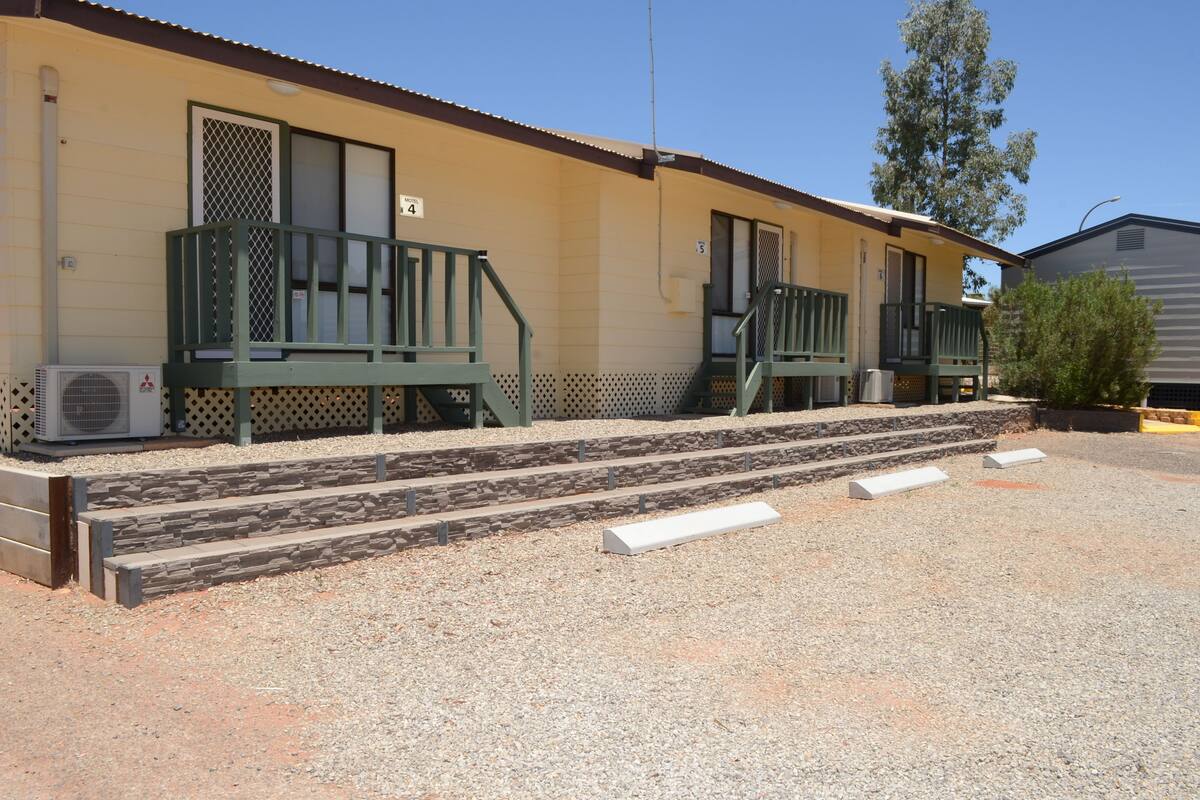 A motel with two units, each with a balcony and a small porch.