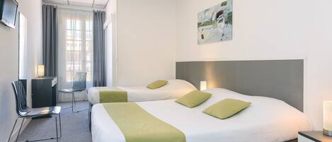 A hotel room with two beds, a desk, a chair, a TV, and a painting on the wall.