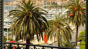 A balcony with a view of a marina and a coastal town. - Hôtel El Paradiso (Menton)