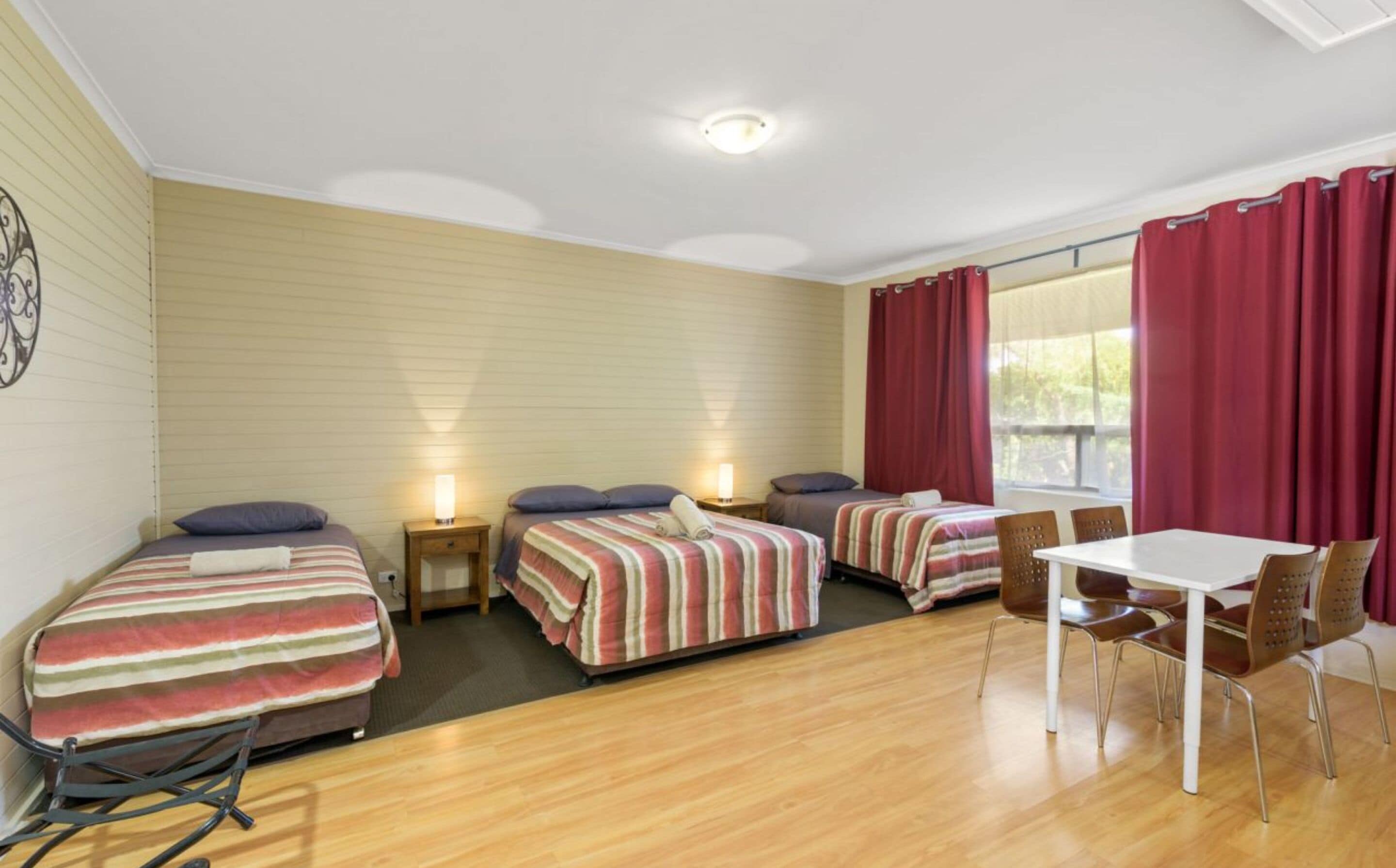 A room with two single beds, a small table, and chairs.