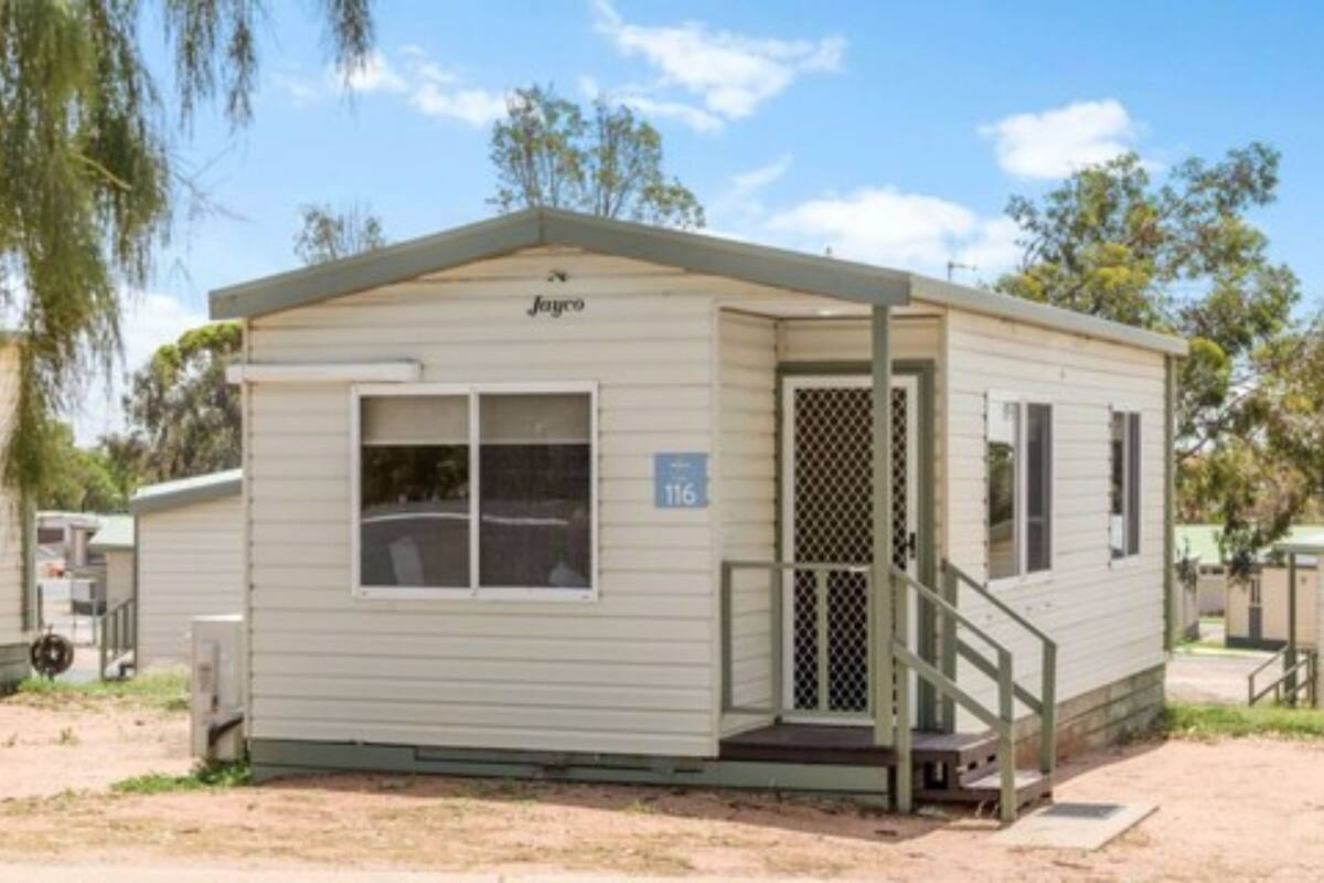 A single-story mobile home with a front porch and a small staircase.