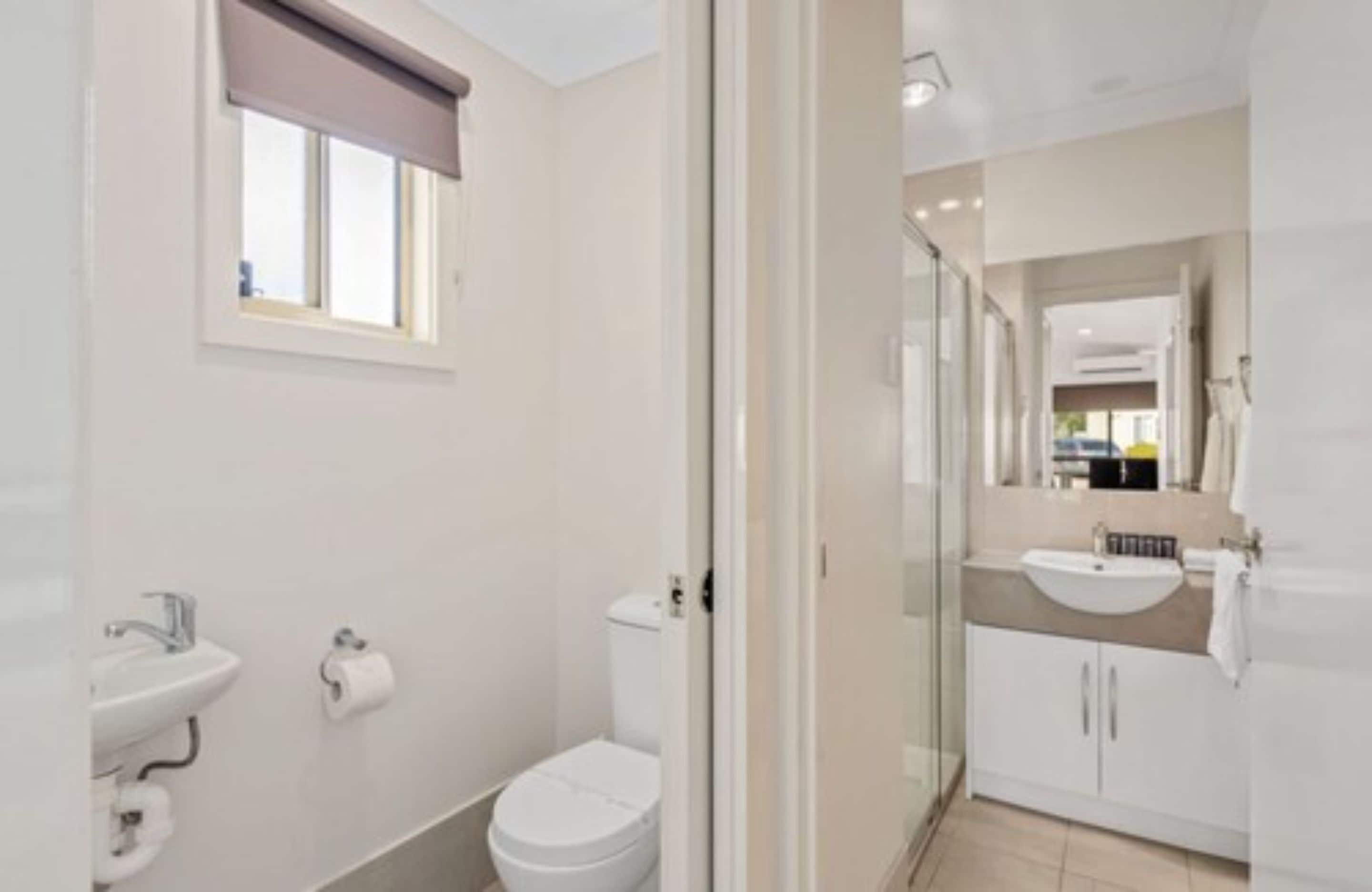 A modern bathroom with a toilet, sink, and shower area.