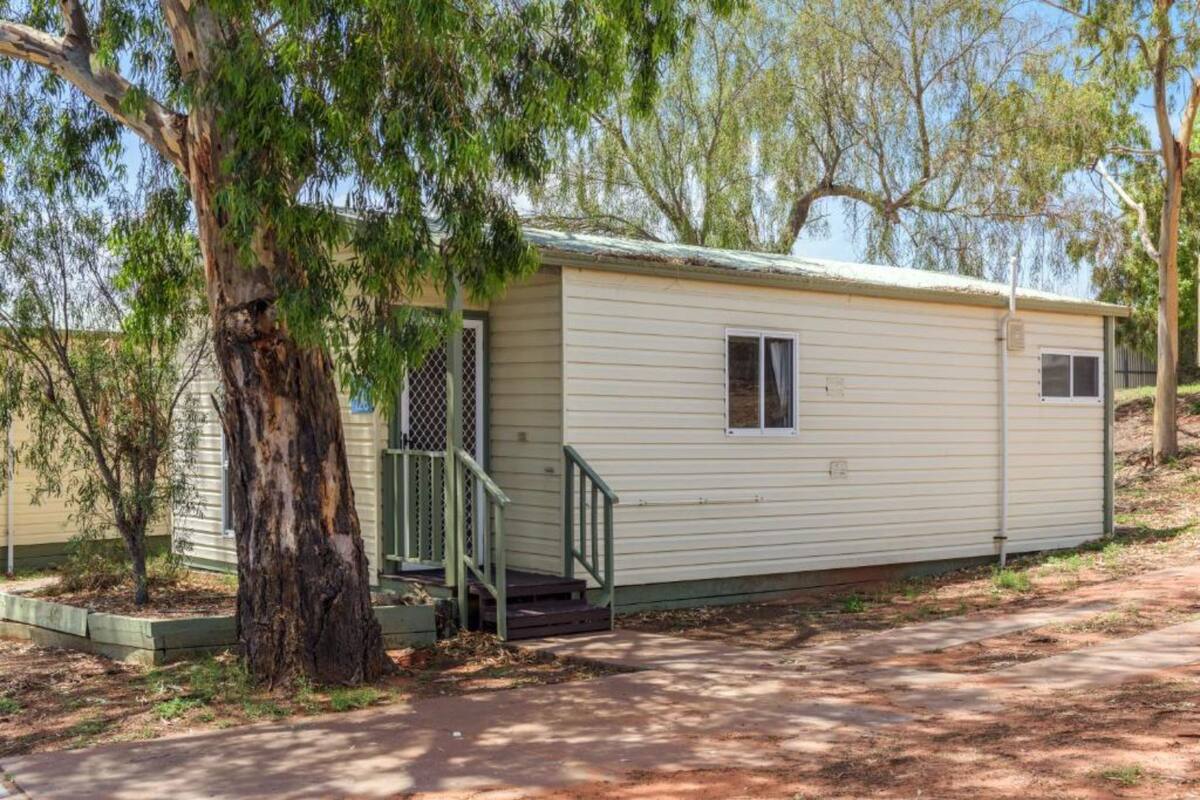 A single-story mobile home with a front porch and a small window.