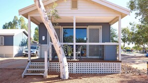 A single-story house with a covered porch, a small staircase, and a car parked outside. - RAC Exmouth Cape Holiday Park (Exmouth)