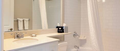 A modern bathroom with a white sink, vanity, and toilet.