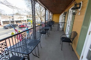 Enjoy the view from this balcony with a street view, featuring a table and chairs.