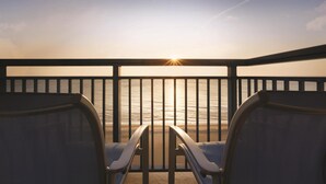 A balcony with two chairs facing a sunset over the ocean. - Hyatt House Virginia Beach / Oceanfront (Virginia Beach)
