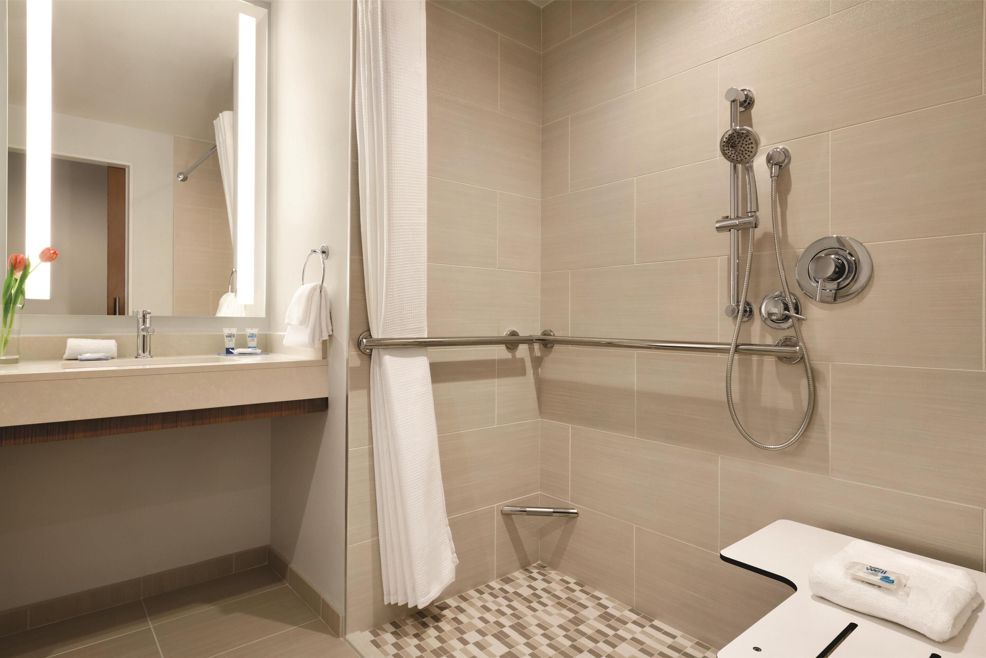 A modern bathroom with a shower, a toilet, and a sink.