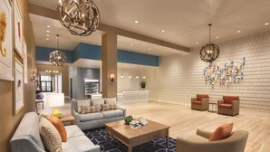 A spacious living area with a modern design, featuring a sofa, armchairs, a coffee table, and decorative lighting. - Hyatt House Virginia Beach / Oceanfront (Virginia Beach)