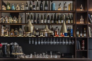 Una zona de bar con estanterías llenas de botellas de licor y copas.