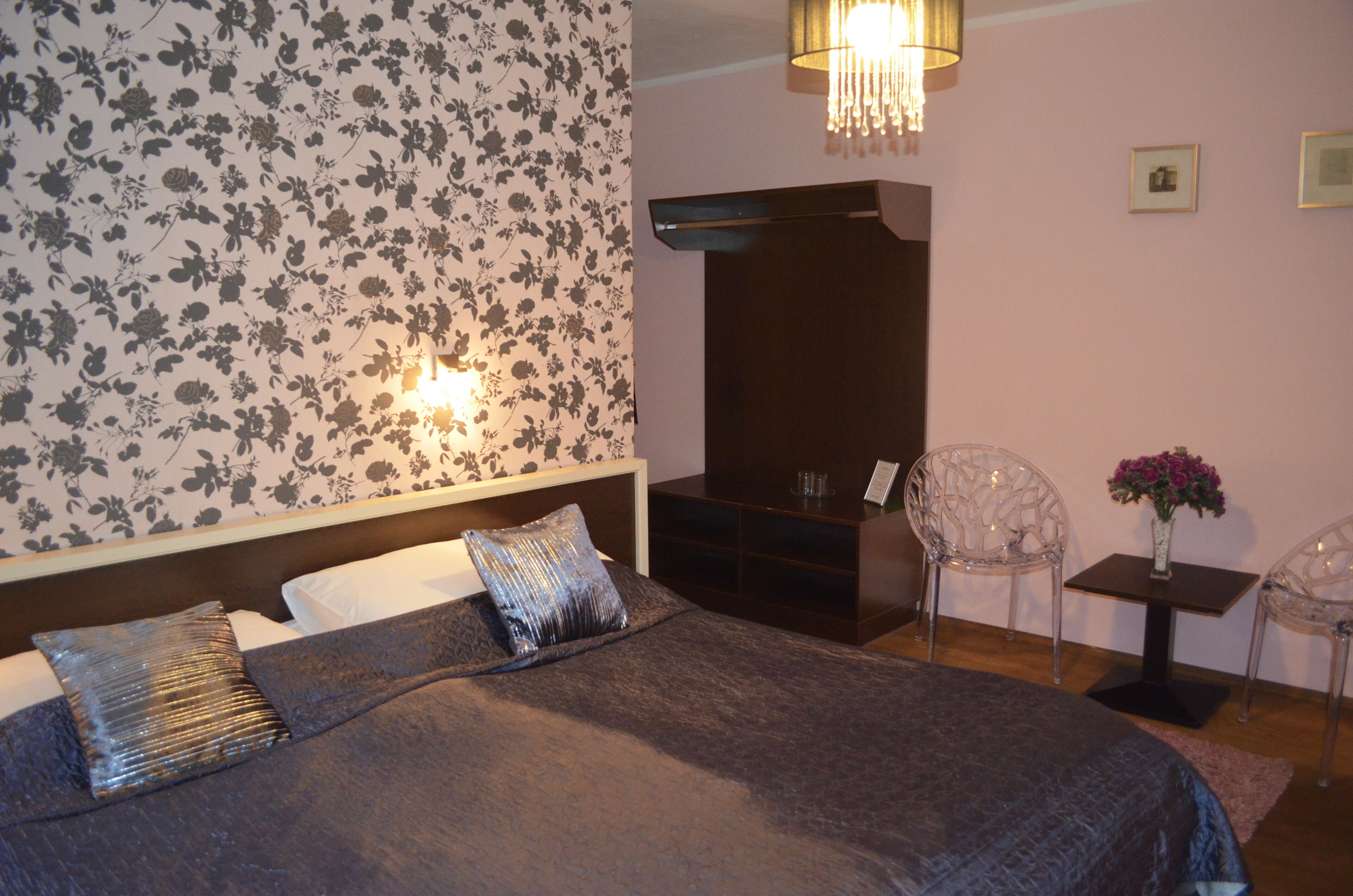 A bedroom with a bed, a nightstand, a dresser, and a chair.