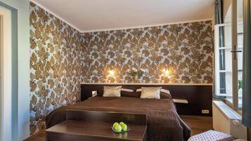 Un dormitorio con una cama grande, una mesita de noche con manzanas y una ventana con cortinas.