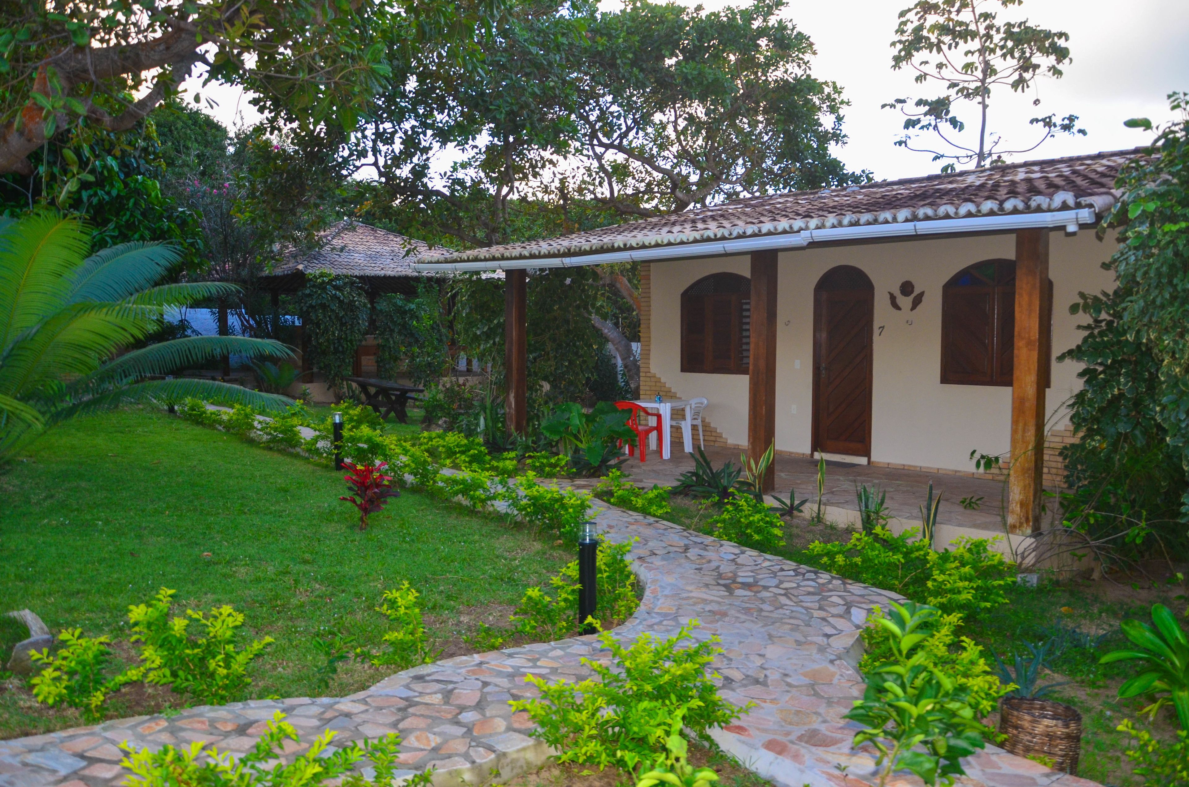 Una casa con techo de tejas, un porche cubierto y un camino de piedra que lleva a la entrada.