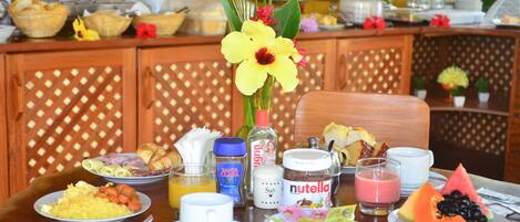 A breakfast buffet with various dishes, including fruits, pastries, and beverages.