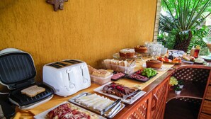 Un tavolo del buffet con diversi cibi, un tostapane e una griglia.