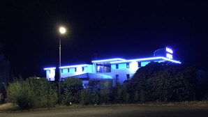 Un edificio con diverse finestre e un tetto piatto, immerso nel verde.