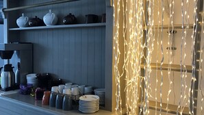 Una cucina con scaffali che contengono utensili da cucina, una macchina per il caffè e oggetti decorativi.