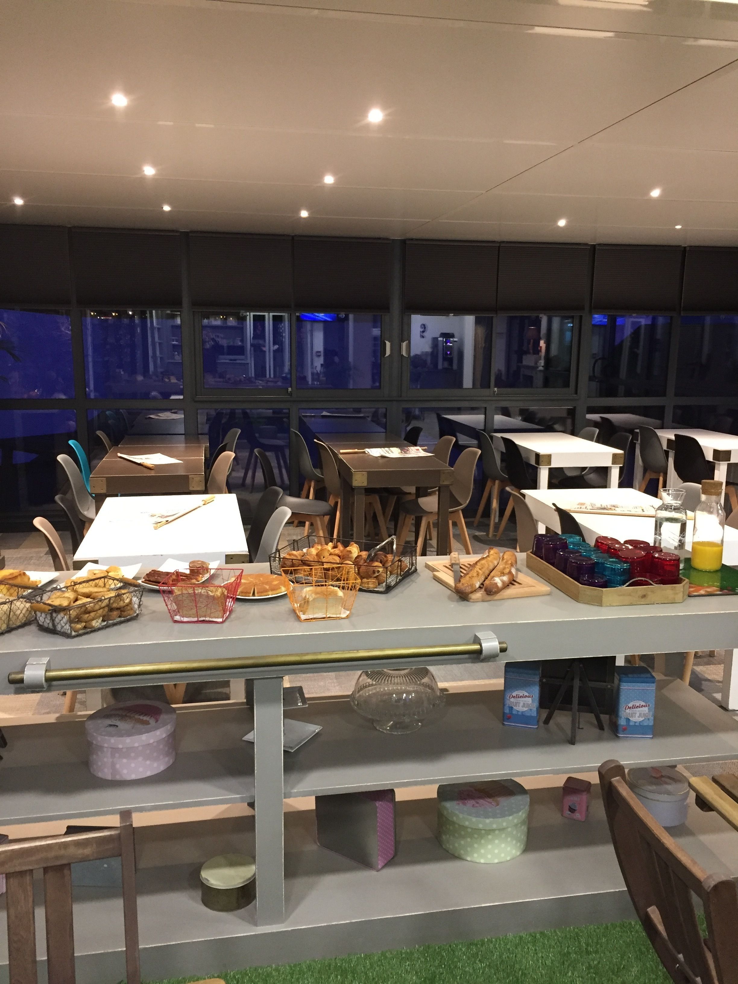 A buffet area with tables and chairs, food items, and beverage dispensers.