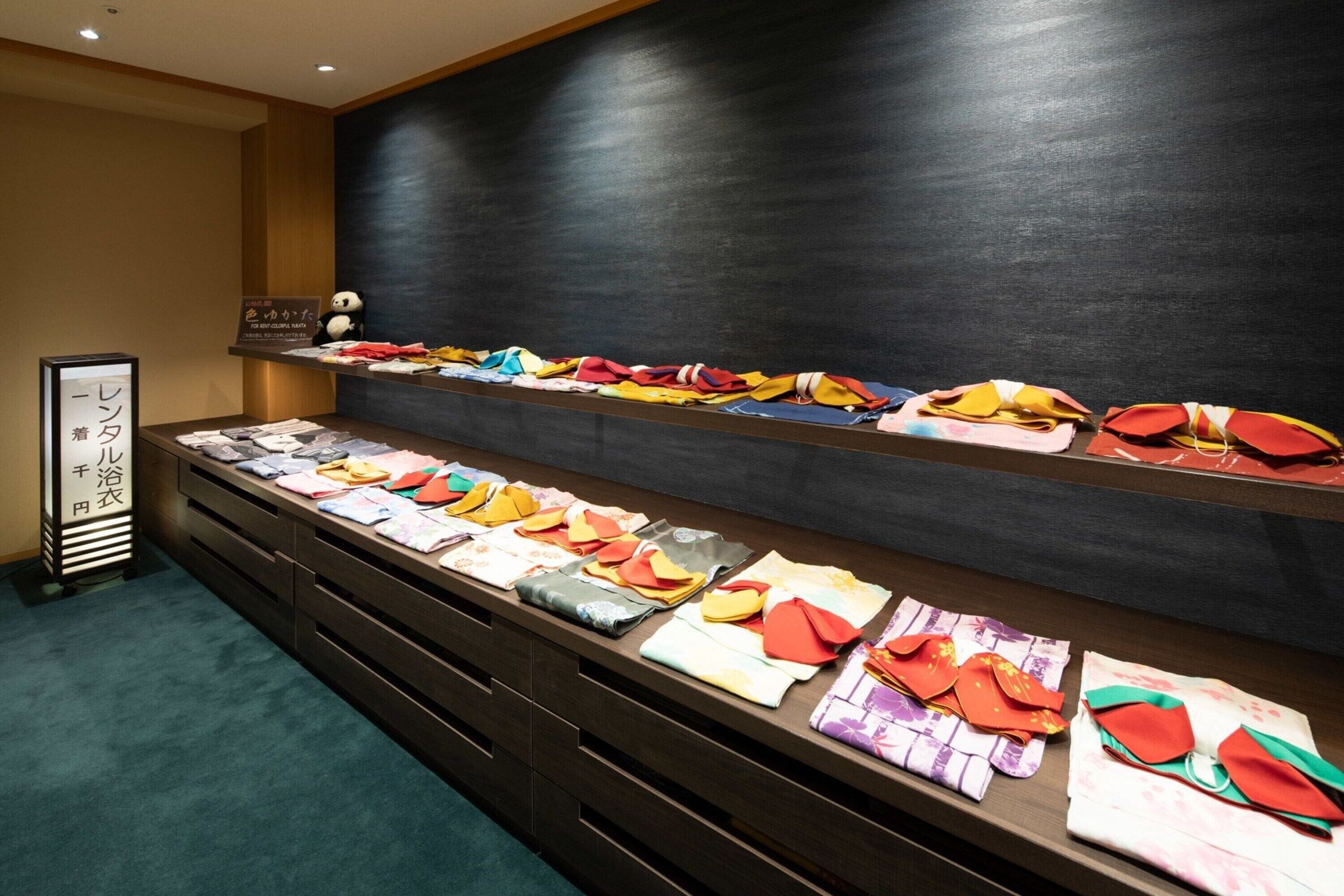 A display of colorful traditional garments on shelves and drawers.