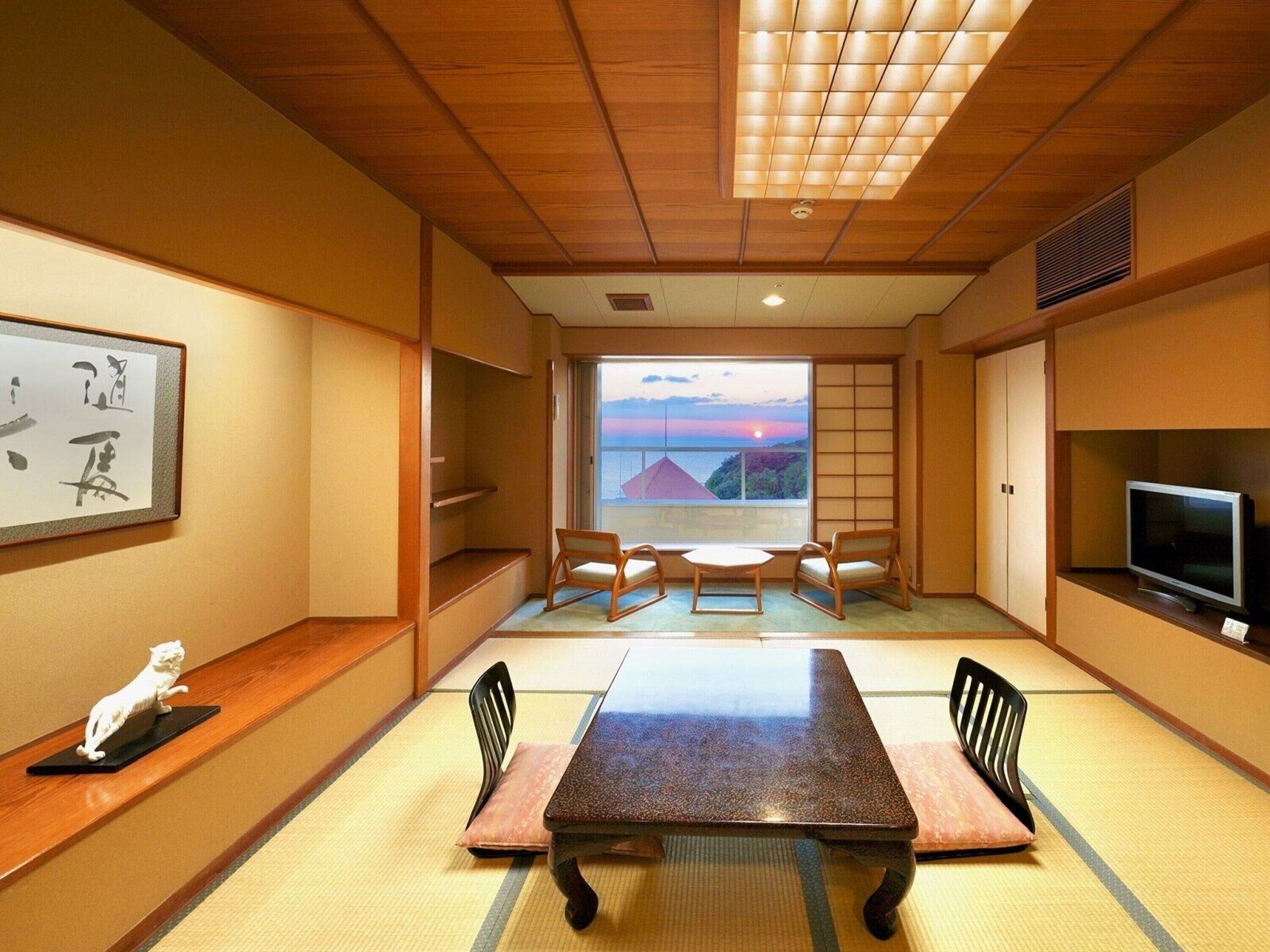 A traditional Japanese-style room with tatami flooring, a low table, and a television.