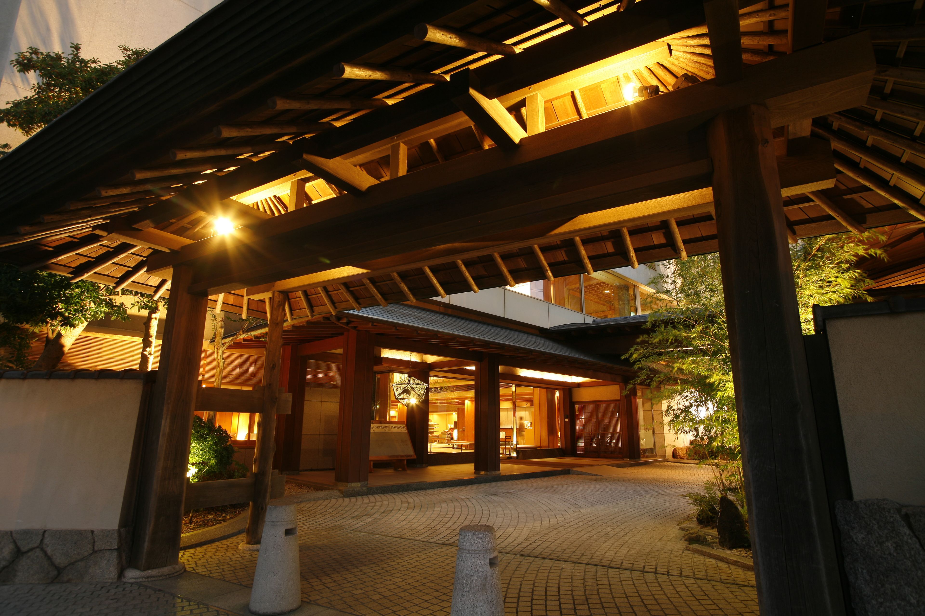 A traditional wooden building with a covered entrance and a tiled pathway leading to it.