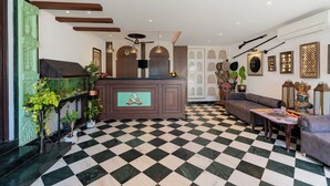 A lobby with a checkered floor, a reception desk, sofas, and decorative items. - Panna Vilas - A Lake Facing Boutique Hotel (Udaipur)