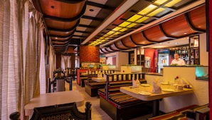 A restaurant with booths and tables, a bar area, and a Pepsi refrigerator.