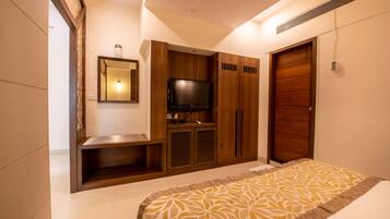 Un dormitorio con cama, televisor, armario de madera y espejo.